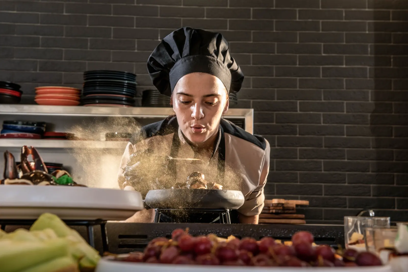 Chef dusting icing sugar over a dessert at the buffet